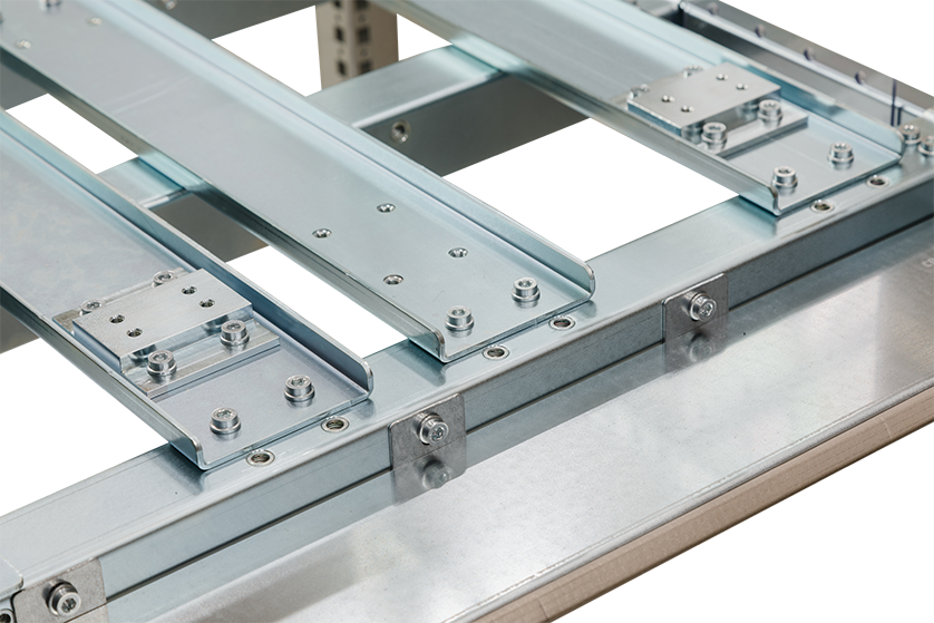 Nahaufnahme eines Metallgleitschienensystems mit Bolzen und Halterungen, das die mechanischen Komponenten und Montagedetails auf einem Stahlrahmen zeigt.