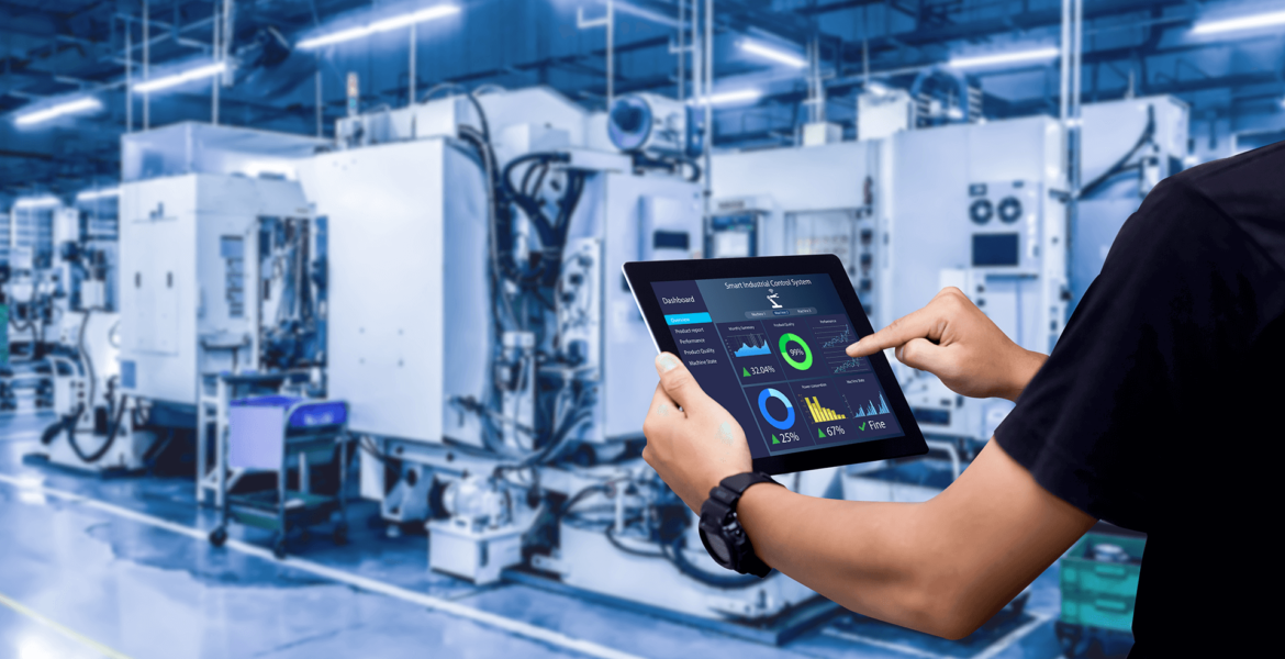 Eine Person verwendet ein Tablet, das Datenanalysen und Grafiken in einer modernen Fabrik mit großen Industriemaschinen im Hintergrund anzeigt.